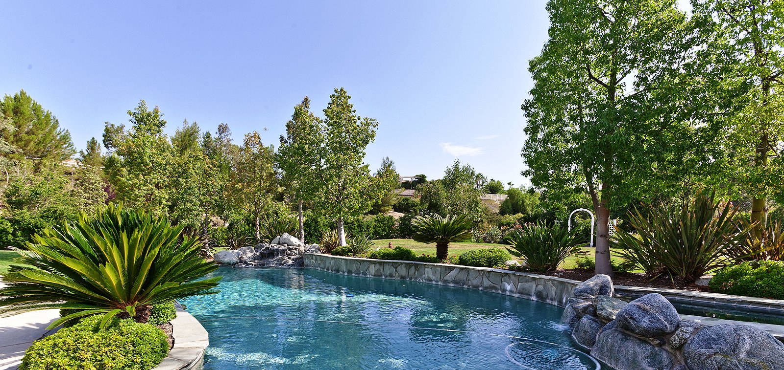 THE HENSLEY GROUP REAL ESTATE - beautiful swimming pool amidst lush greens