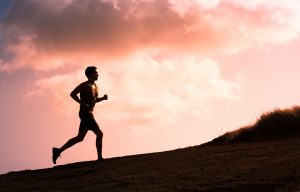 Fitness male running outdoors during sunset