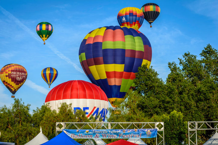 Colorful balloons ascend into the morning sky